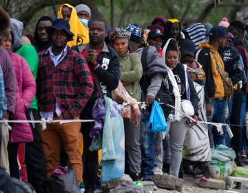 A group of people stand in a line.