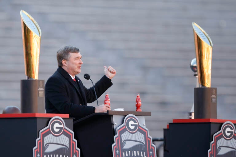 Georgia head coach Kirby Smart speaks while standing between the 2022 and 2023 championship trophies during a ceremony celebrating the Bulldog's second consecutive NCAA college football national championship, Saturday, Jan. 14, 2023, in Athens, Ga.