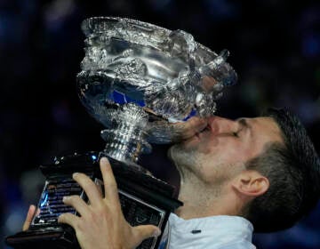 Novak Djokovic of Serbia kisses the Norman Brookes Challenge Cup after defeating Stefanos Tsitsipas of Greece in the men's singles final at the Australian Open