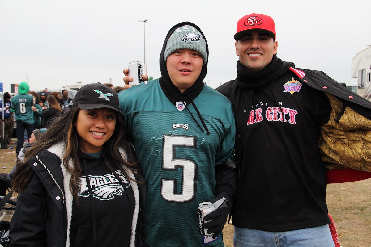 Two Philadelphia Eagles fans and a San Francisco 49ers fan pose together ahead of the NFC Championship game