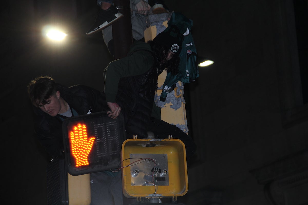 Fans began dismantling a street light right next to City Hall as the impromptu Eagles NFC Championship party was underway