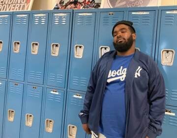 Chicago native Phillip Griffin stands in front of a set of school lockers