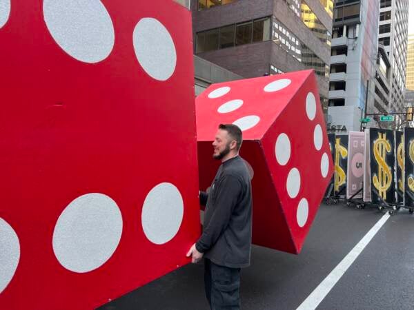 James Holden of the Greater Kensington String Band positions a pair of dice for their Monopoly themed performance (Jonathan Wilson for WHYY)