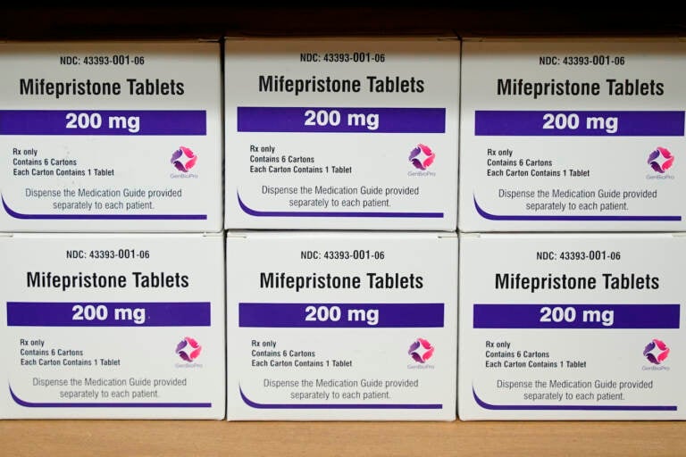 Boxes of pills on a counter at a pharmacy.