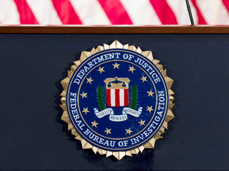 The FBI seal is displayed on a podium.