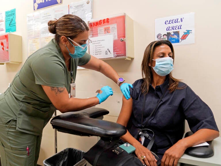 Licensed vocational nurse Denise Saldana vaccinates Pri DeSilva, associate director of Individual and Corporate Giving, with a fourth Pfizer COVID-19 vaccine booster at the Dr. Kenneth Williams Health Center in Los Angeles, Nov. 1, 2022. (Damian Dovarganes/AP)