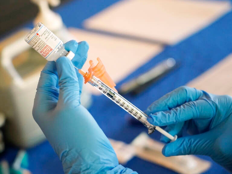 A nurse prepares a syringe of a COVID-19 vaccine at an inoculation station in Jackson, Miss.