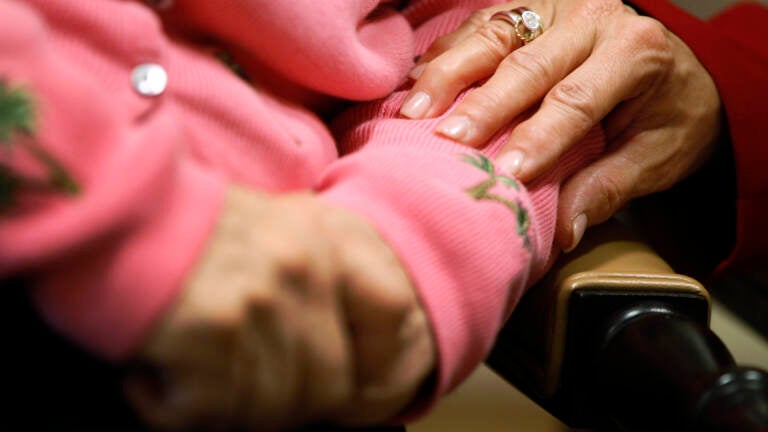 An upclose shot of two people holding hands.