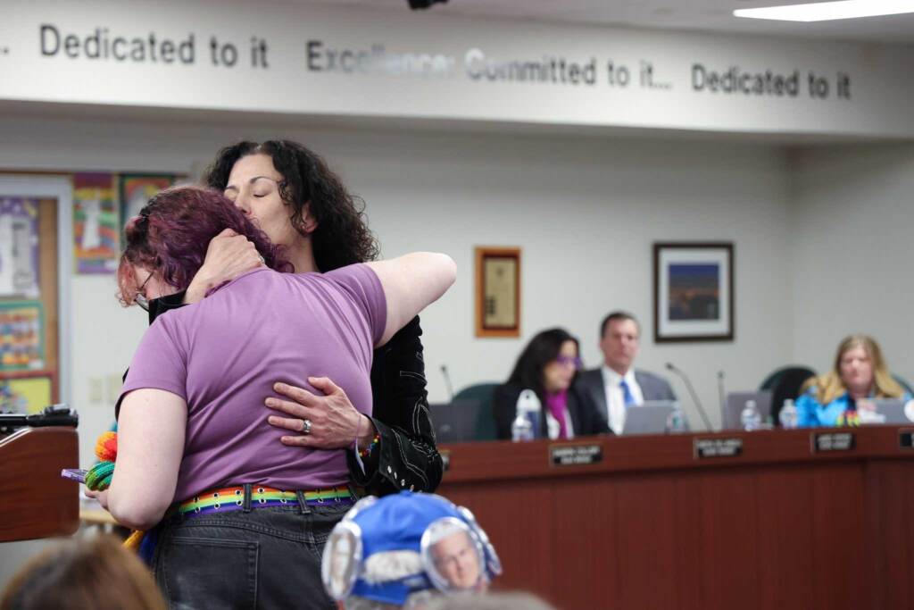 Kathleen Weintraub hugs their child, CJ, at a school board meeting in Central Bucks