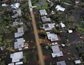 An aerial view of a row of homes and flooded streets.