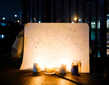 Candles are placed in front of a sign that reads 