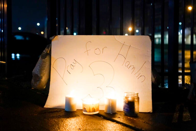 Candles are placed in front of a sign that reads 