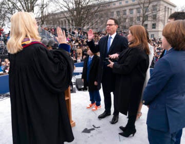 Debra Todd, seen from behind, administers the oath of office to Gov. Josh Shapiro.