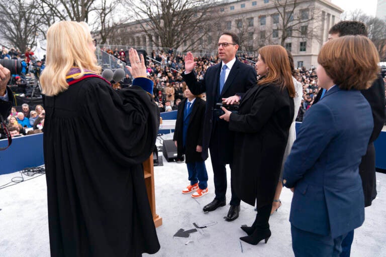 Debra Todd, seen from behind, administers the oath of office to Gov. Josh Shapiro.