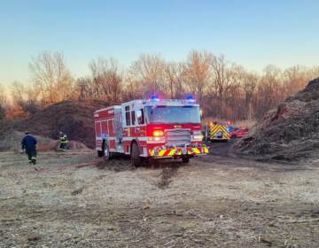 A firetruck stands at a waste dump site.