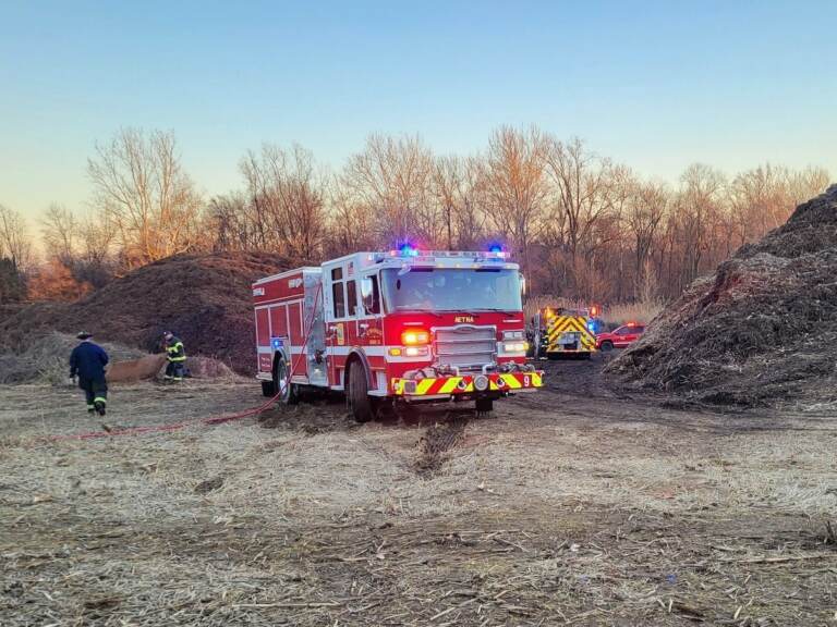 A firetruck stands at a waste dump site.