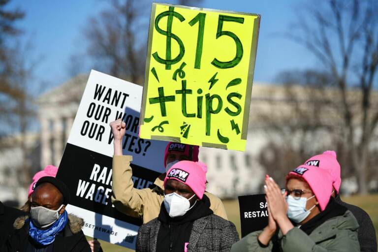 A person holds up a sign that reads