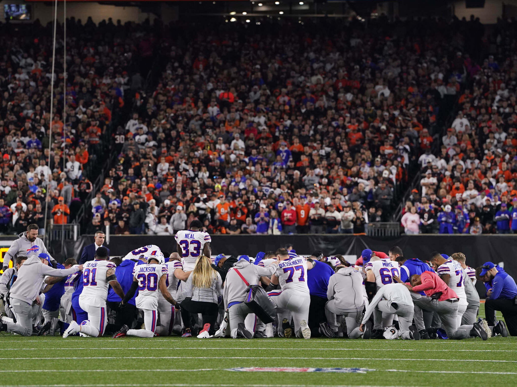 Buffalo Bills players huddle and pray after teammate Damar Hamlin collapsed on the field after making a tackle against the Cincinnati Bengals during the first quarter at Paycor Stadium on Monday in Cincinnati, Ohio. (Dylan Buell/Getty Images)