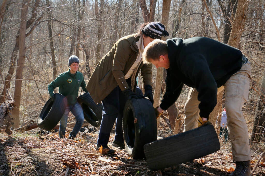 From left to right: Matt Kuentzler, Alexandra Khalil, and Erik Silldorff of Doylestown help clean up hundreds of tires by Tacony Creek Park