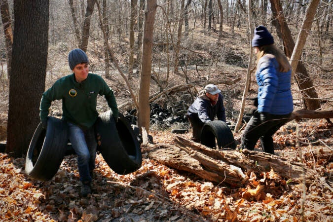 Matt Kuentzler and other volunteers help clean up tires by Tacony Creek Park