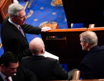 McCarthy stands with a group of people on the House floor.