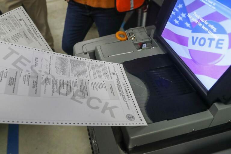 A ballot is fed into a voting machine.