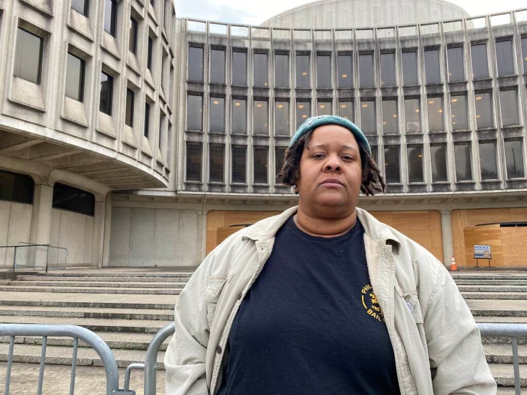 A woman stands in front of the Roundhouse building.