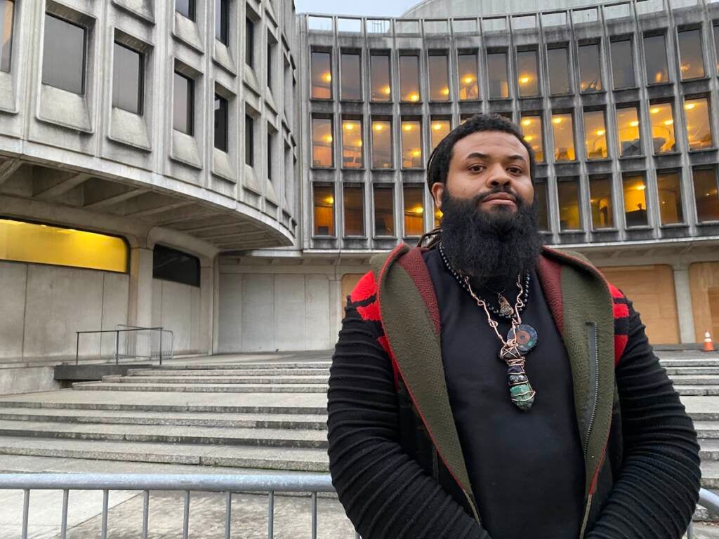 A man stands in front of the Roundhouse building.