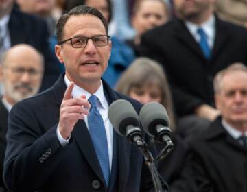 Josh Shapiro speaks into a microphone at his gubernatorial inauguration.