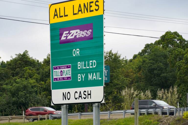 A sign reads E-ZPass. The highway is visible in the background.