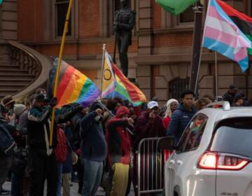 A group of protesters carry Pride flags outside of the Union League.
