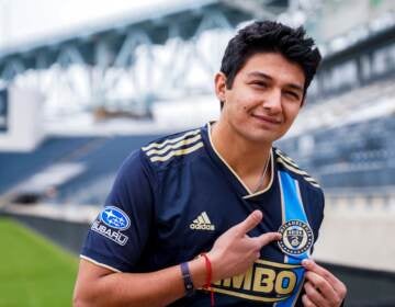 Thiago Vazquez points to the Philadelphia Union badge on his shirt during his signing day