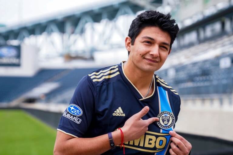 Thiago Vazquez points to the Philadelphia Union badge on his shirt during his signing day