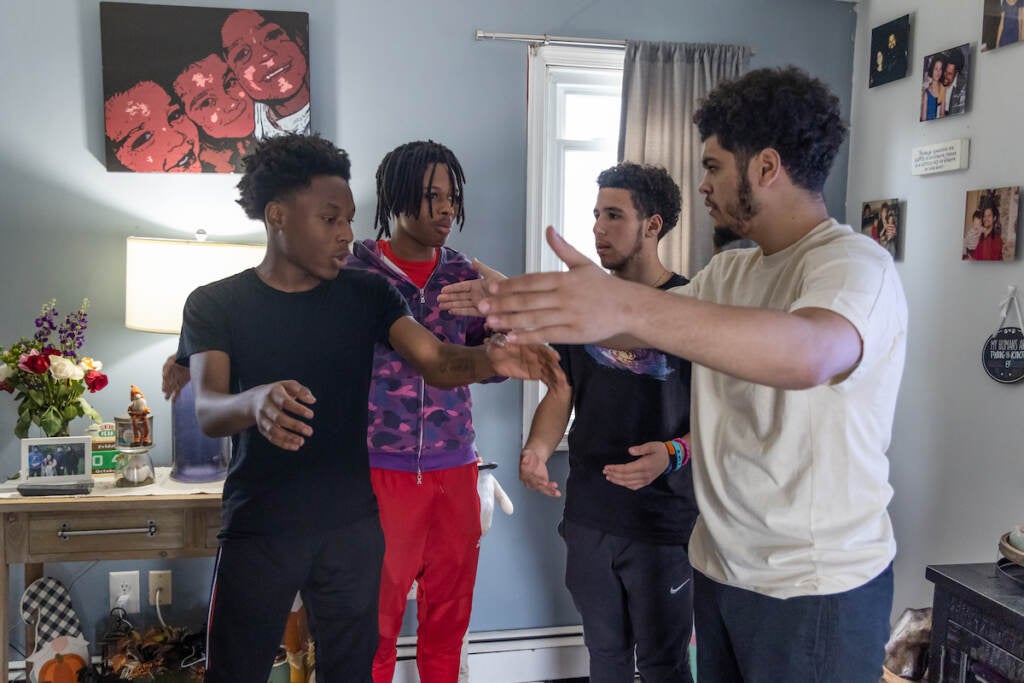 A group of friends talk as they stand in a circle.