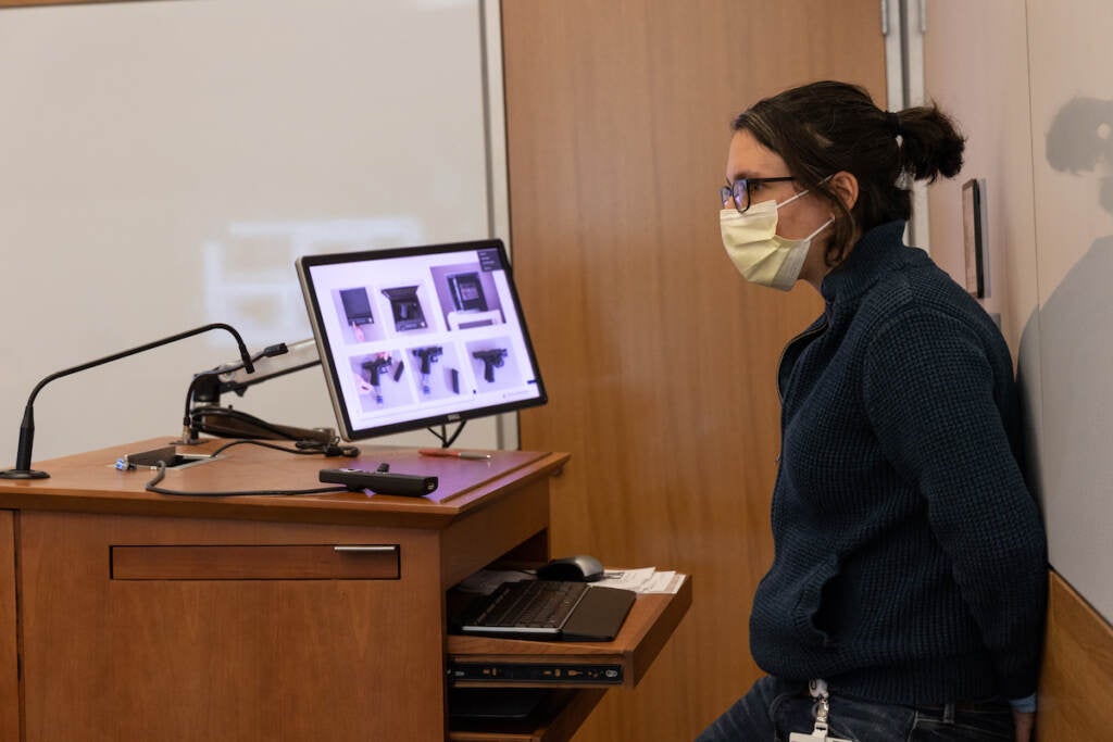 A person stands at the front of a classroom.