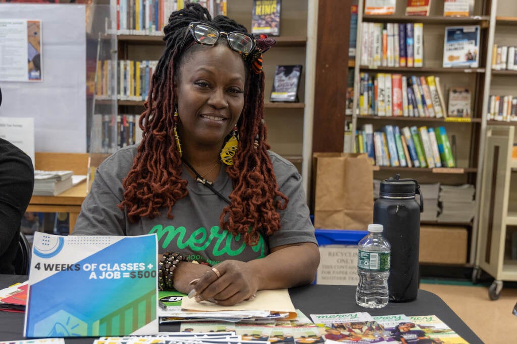 Nicole Cobb sits at a table and smiles, posing for the photo.