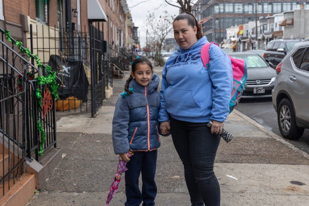 Bridget and Lu hold hands on their walk to school