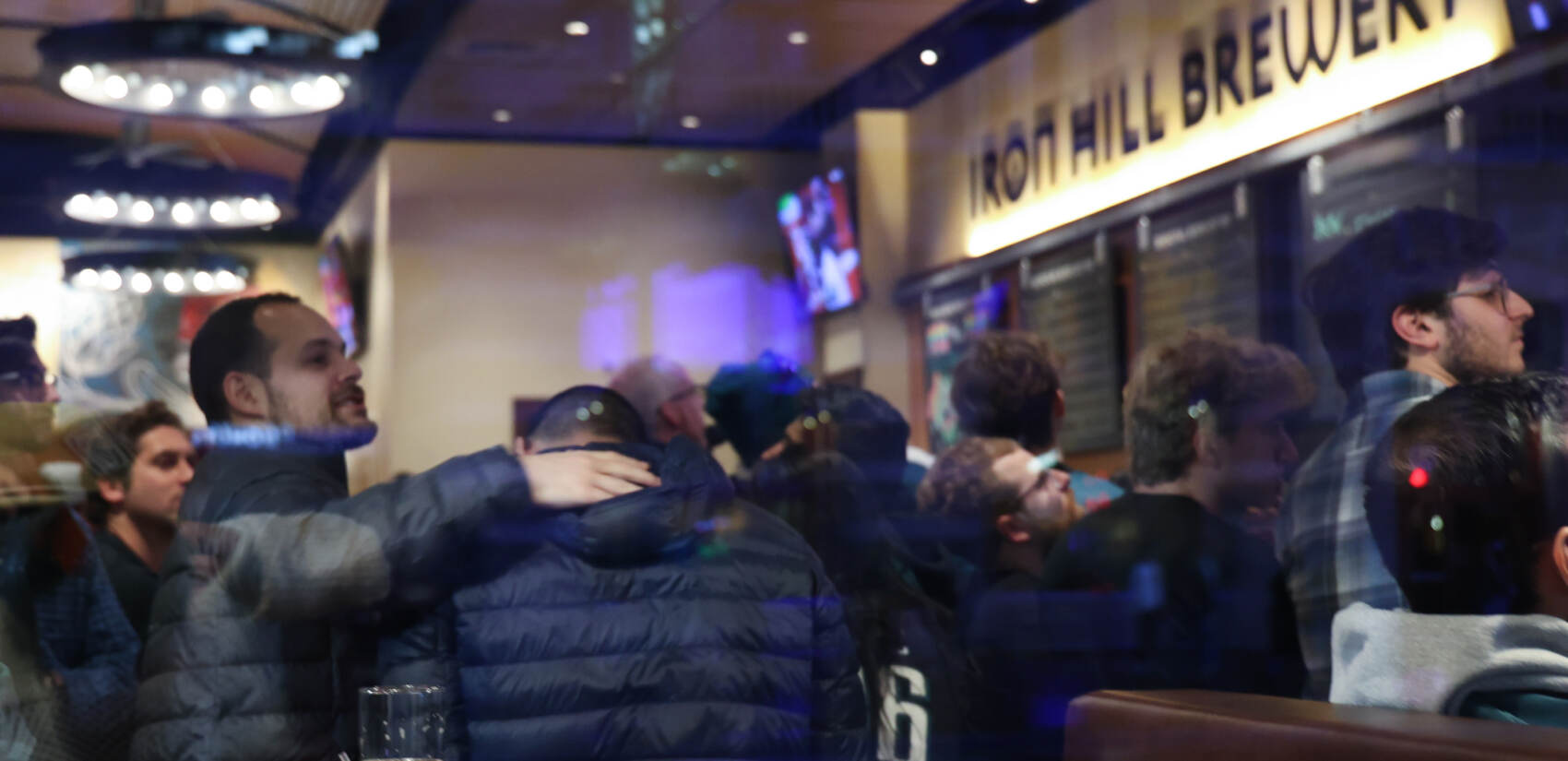 Eagles fans offer each other comfort at Iron Hill Brewery in Center City, Philadelphia, after Kansas City Chiefs beat the birds 38-35, on February 12, 2023. (Kimberly Paynter/WHYY)