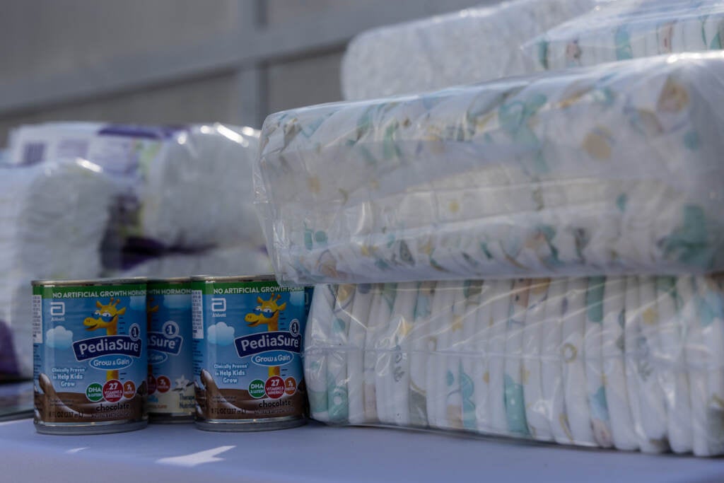 A close-up of cans of Pediasure and bags of diapers.