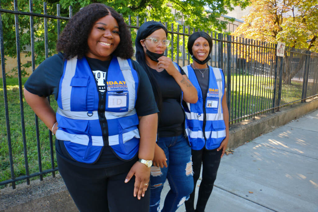 Three people pose for a photo in safety vests.