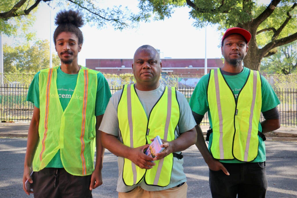 Three people in safety vests pose for a photo.