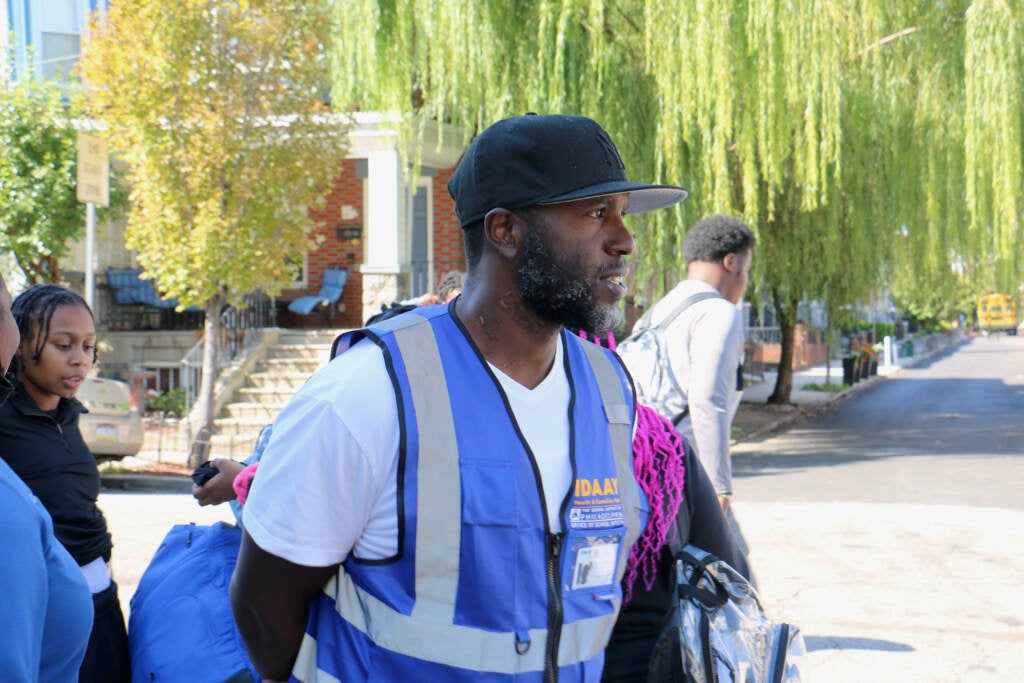 Malik Smith looks on as students enter a school building.