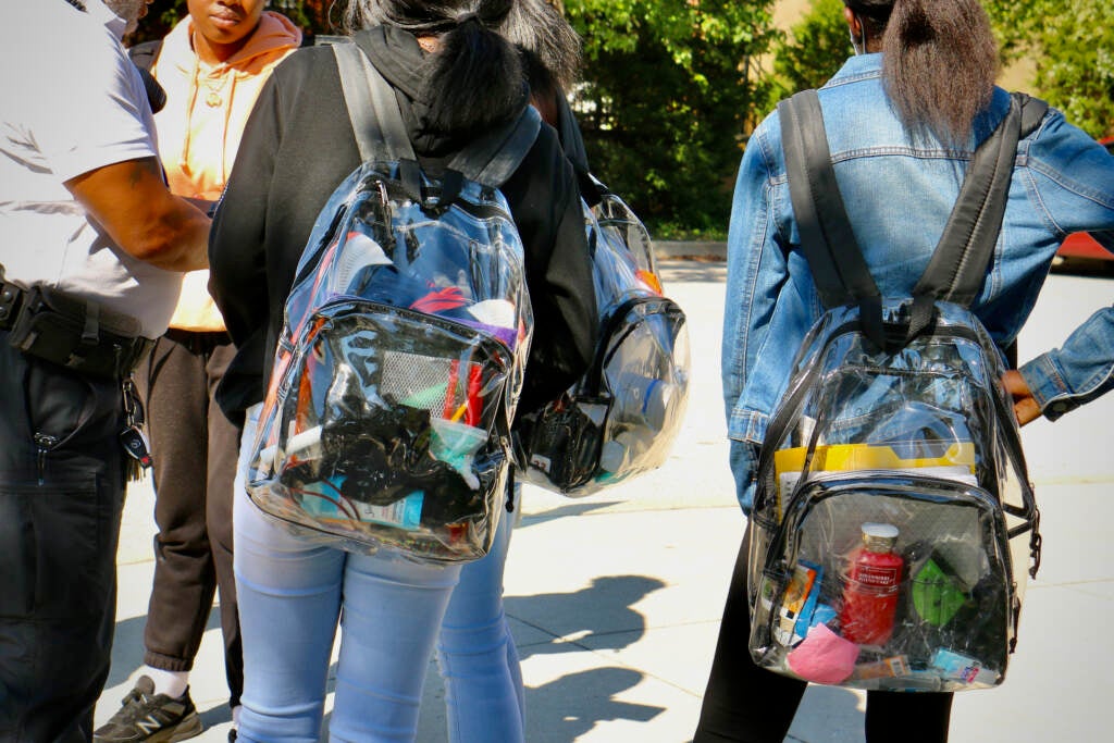 A close-up of students' transparent backpacks.