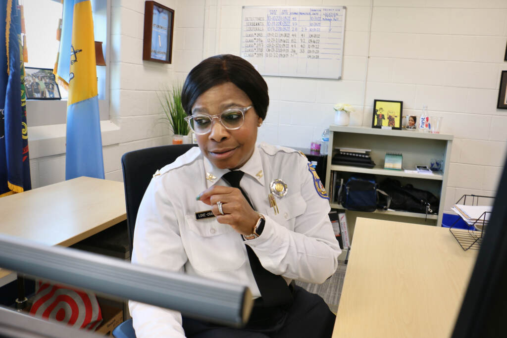 Altovise Love-Craighead sits at her desk, looking off to the side.