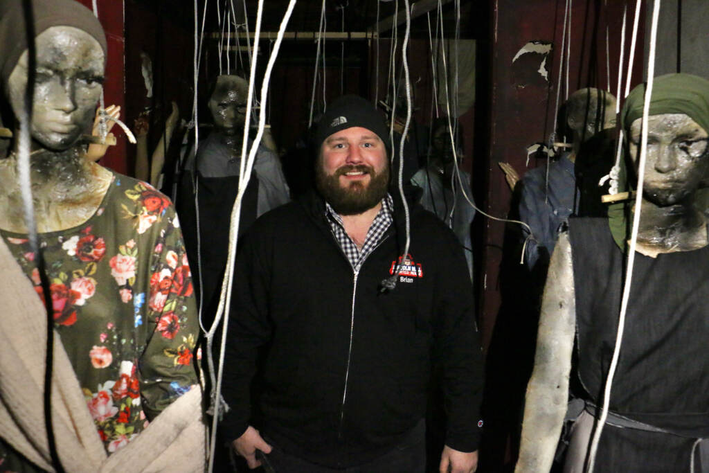 Brian Corcodilos stands between two mannequins in the haunted house.