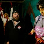 Corcodilos looks towards a mannequin that looks frightening with a sign on their front shirt which is a pink heart that says 