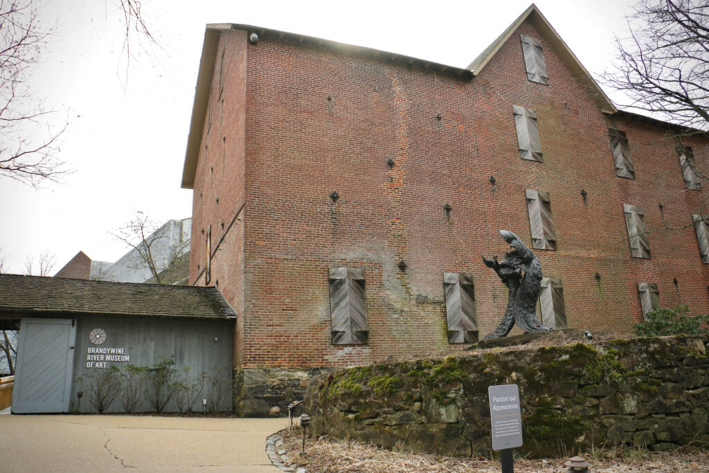 A brick building and a sculpture are visible.