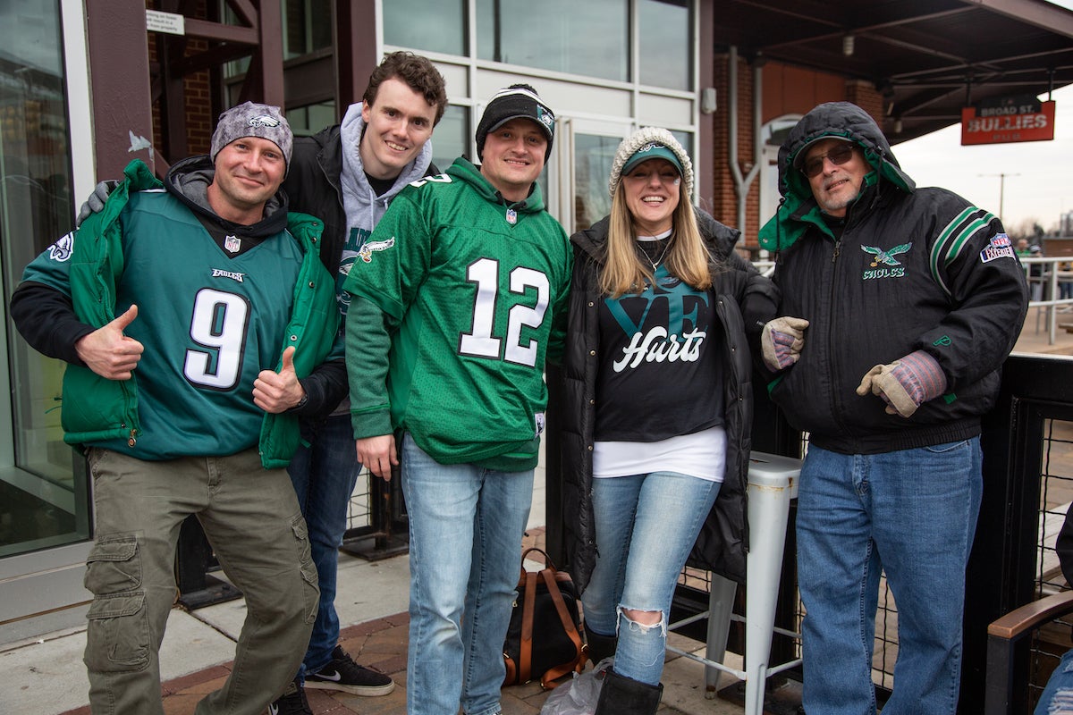 Edward Miloz (left) drove from Lexington. S.C. to Philadelphia to watch the game. Along the way he picked up dad Emil in Myrtle Beach, then brother Adam in Maryland, before meeting up with sister Barbara and her husband Rex in Jersey. They arrived at 11:45 a.m. to be first in line for the indoor Xfinity Live! Super Bowl LVII party. (Emily Cohen for WHYY)