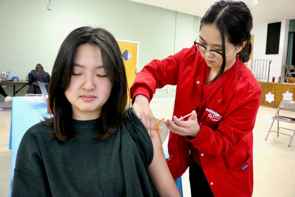 Jenna Kim, 21, of Moorestown gets a COVID-19 booster at a clinic put on by the Camden County Department of Health in the basement of the United Methodist Church in Haddon Heights