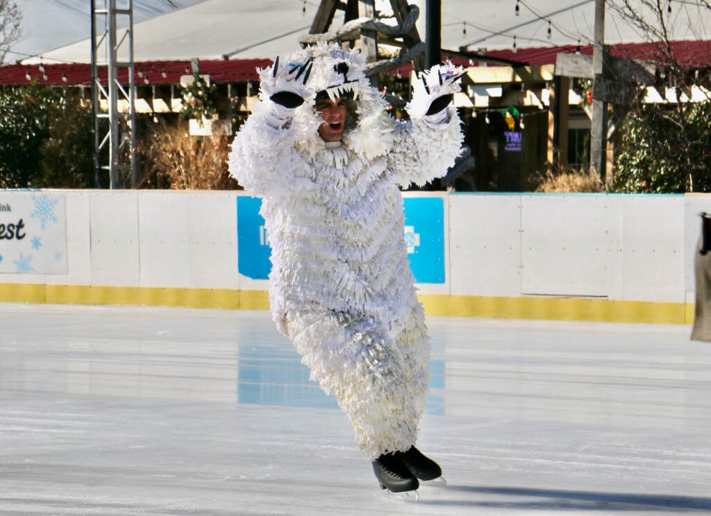 A person skates by in a polar bear costume.